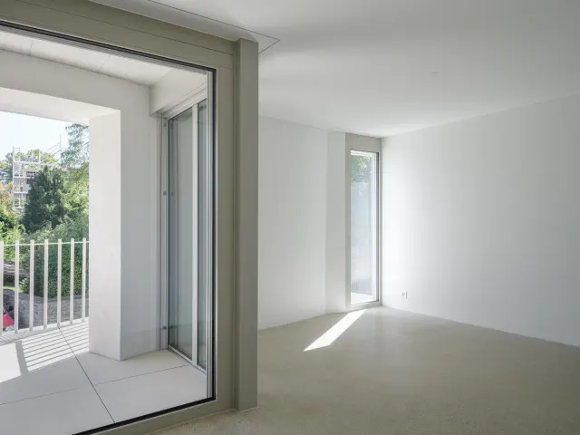 Wohnzimmer mit weiss gestrichenen Wänden und Terrassentür